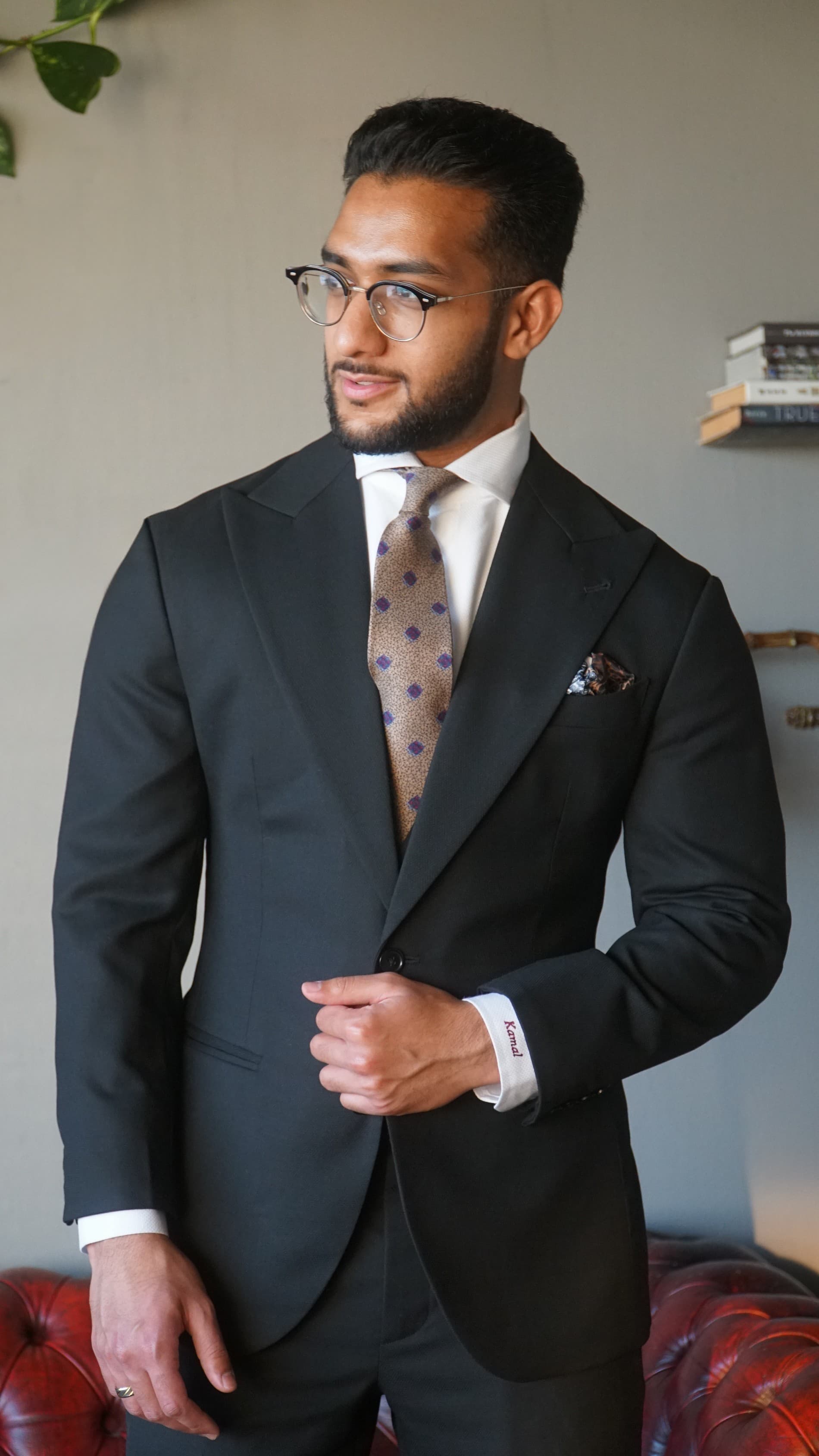 Idrees Kamal, Founder of Kavalier Clothing, in a tailored black suit with a patterned tie