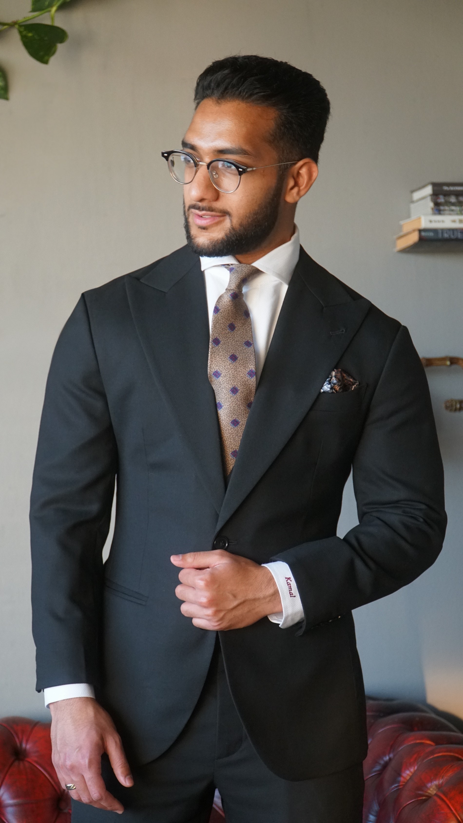 Idrees Kamal, Founder of Kavalier Clothing, in a tailored black suit with a patterned tie